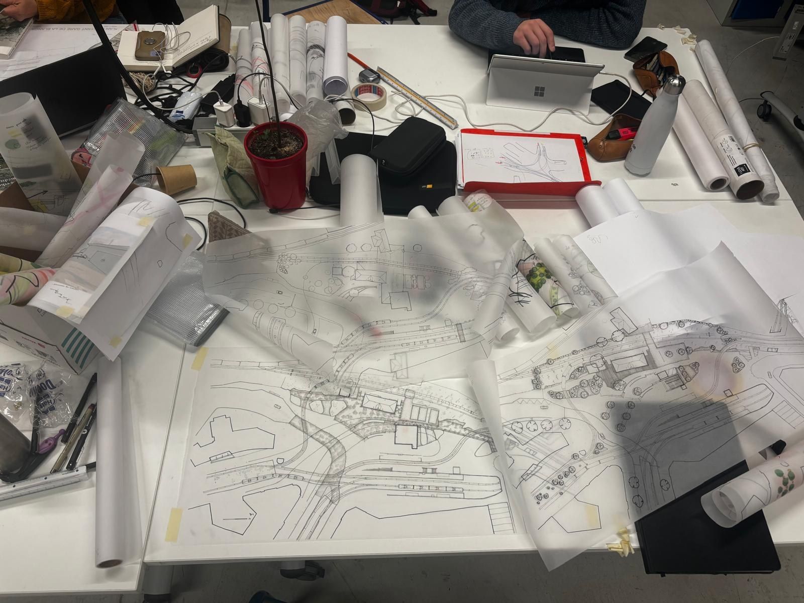 Table d'atelier couverte de rouleaux de calque et de plans en cours