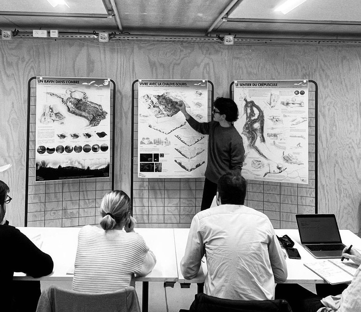 Téo Marsalla présentant ses planches devant un jury : trois panneaux du projet du Sentier du crépuscule