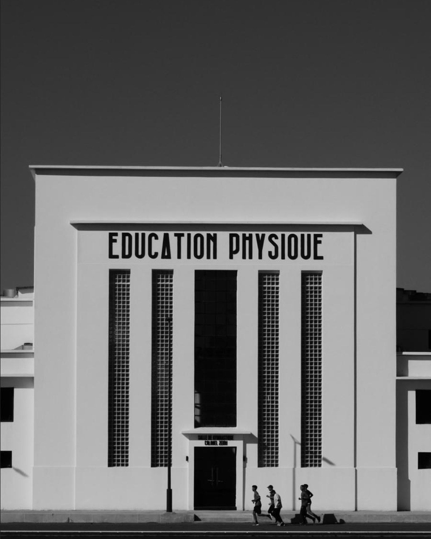 Façade moderniste d'un bâtiment d'éducation physique à Rabat, photographiée en noir et blanc